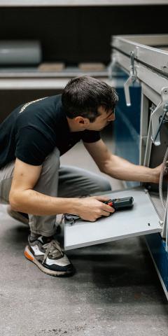 Ein konzentrierter Techniker überprüft die Maschinen im Innenbereich und stellt so die Betriebseffizienz sicher.